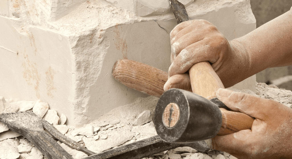 Mains d’un tailleur de pierre maniant le maillet et le ciseau – symbole du travail maçonnique sur la pierre brute – Nos Colonnes