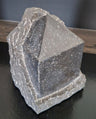 Pyramid sculpture emerging from the material